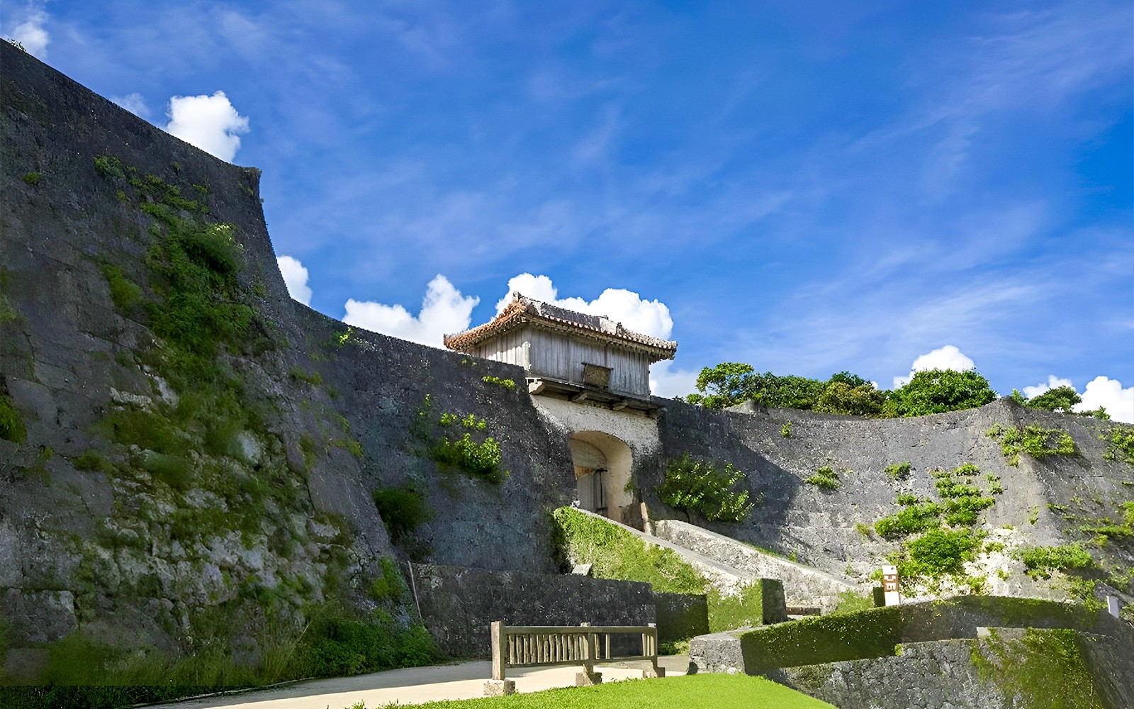 Shurijo Castle Park stone walls and gate under a blue sky in Okinawa, Japan.