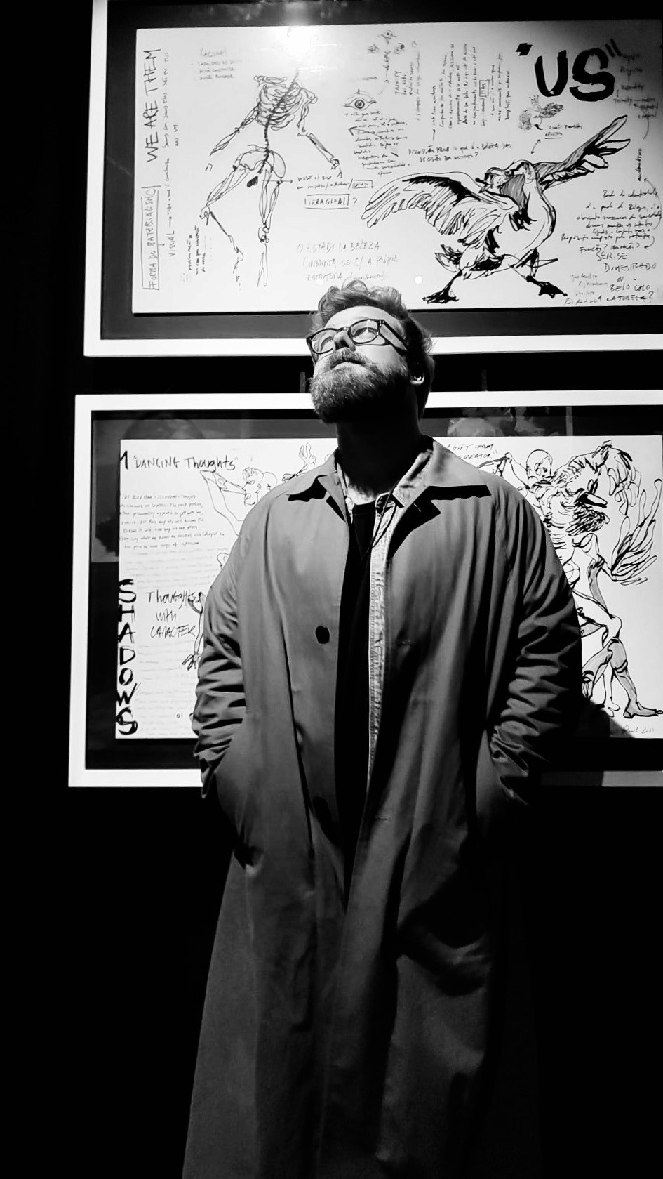 A thoughtful young person with dark hair gazes to the side, captured in soft black and white lighting.