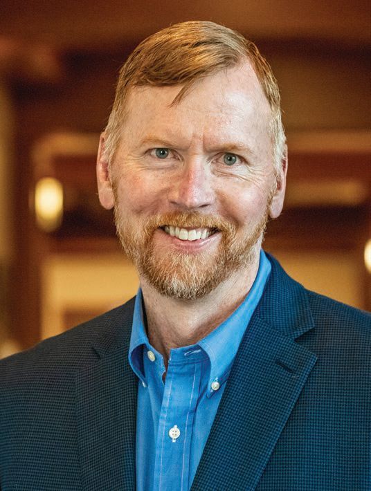 Headshot of CEO Brian Murphy in a blue collar shirt and suit jacket