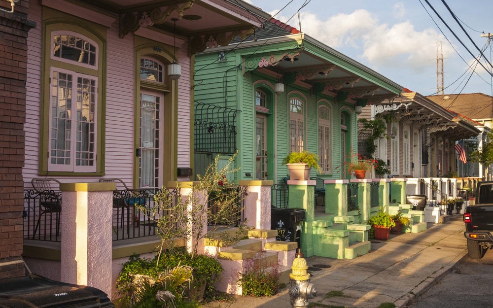 Beautiful image looking down a street at the colorful and ornate architecture of the homes in the Marigny in New Orleans