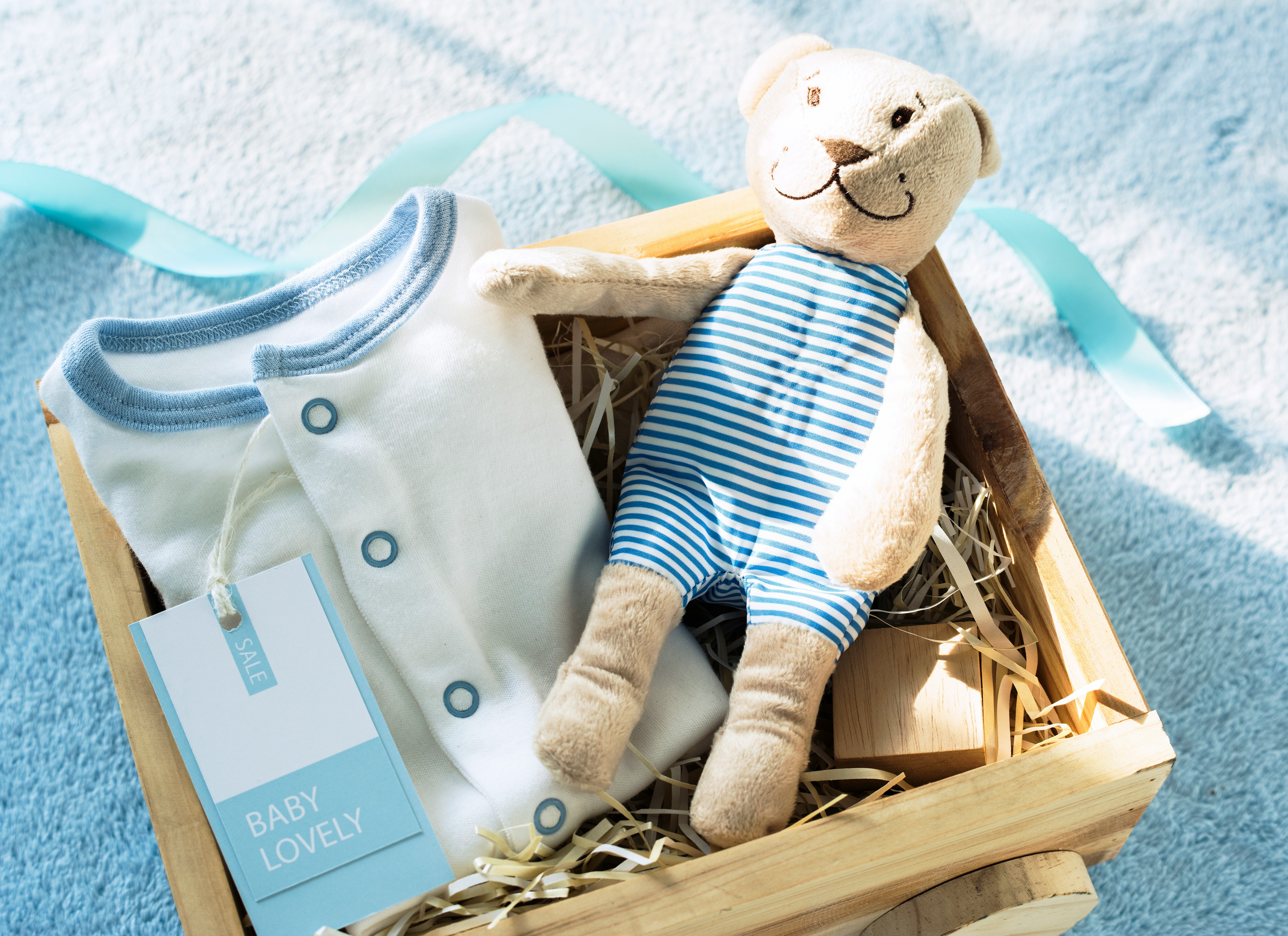 baby clothes and toys in a gift box