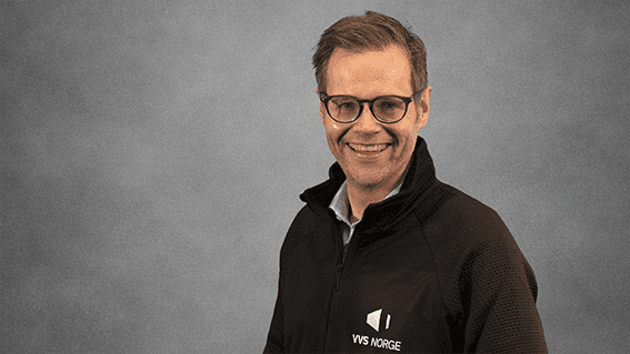 Adm. dir. VVS Norge Kristian Reistadbakken i sort genser med VVS Norge logo på grå bakgrunn