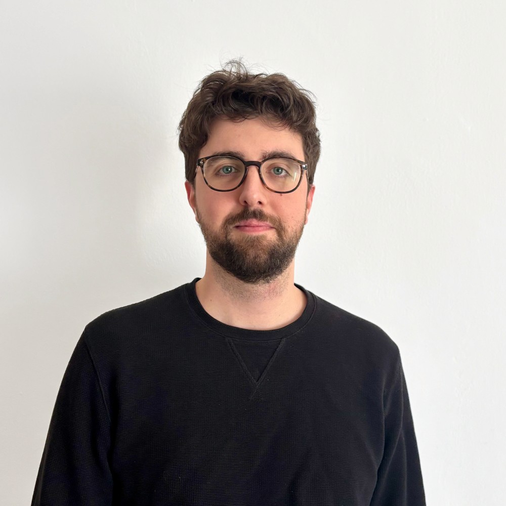 Foto frontale a mezzo busto di Luca Ghiacci, che sorride.
