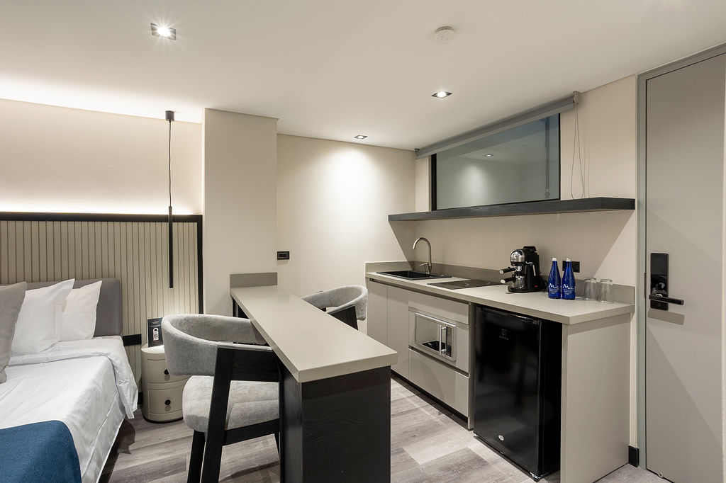 Hotel residencial premium Medellín, suite Altus Comfort con cocina privada, barra americana y vestier para máxima comodidad en estadías prolongadas.