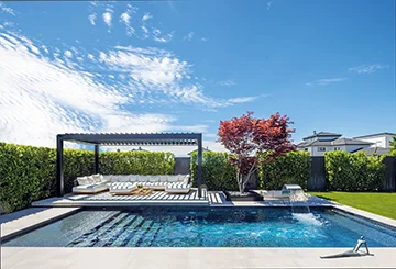 MLine Pool mit dunkler Pergola, Loungebereich und japanischem Ahorn