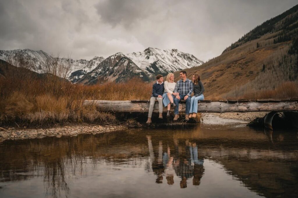 Family on a wooden bridge by a river in Aspen