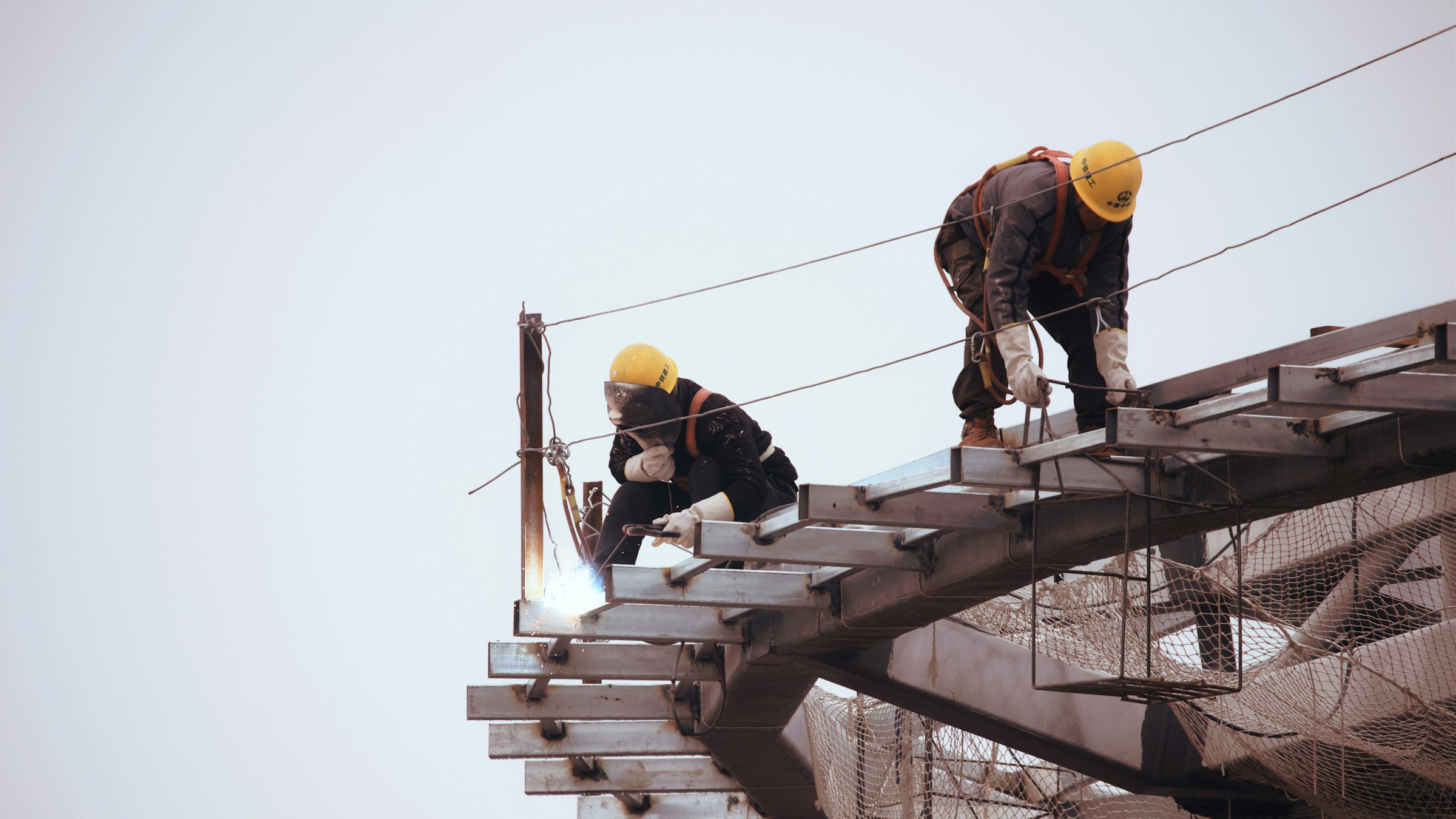 Safety manager in yellow hard hat standing atop a building under construction