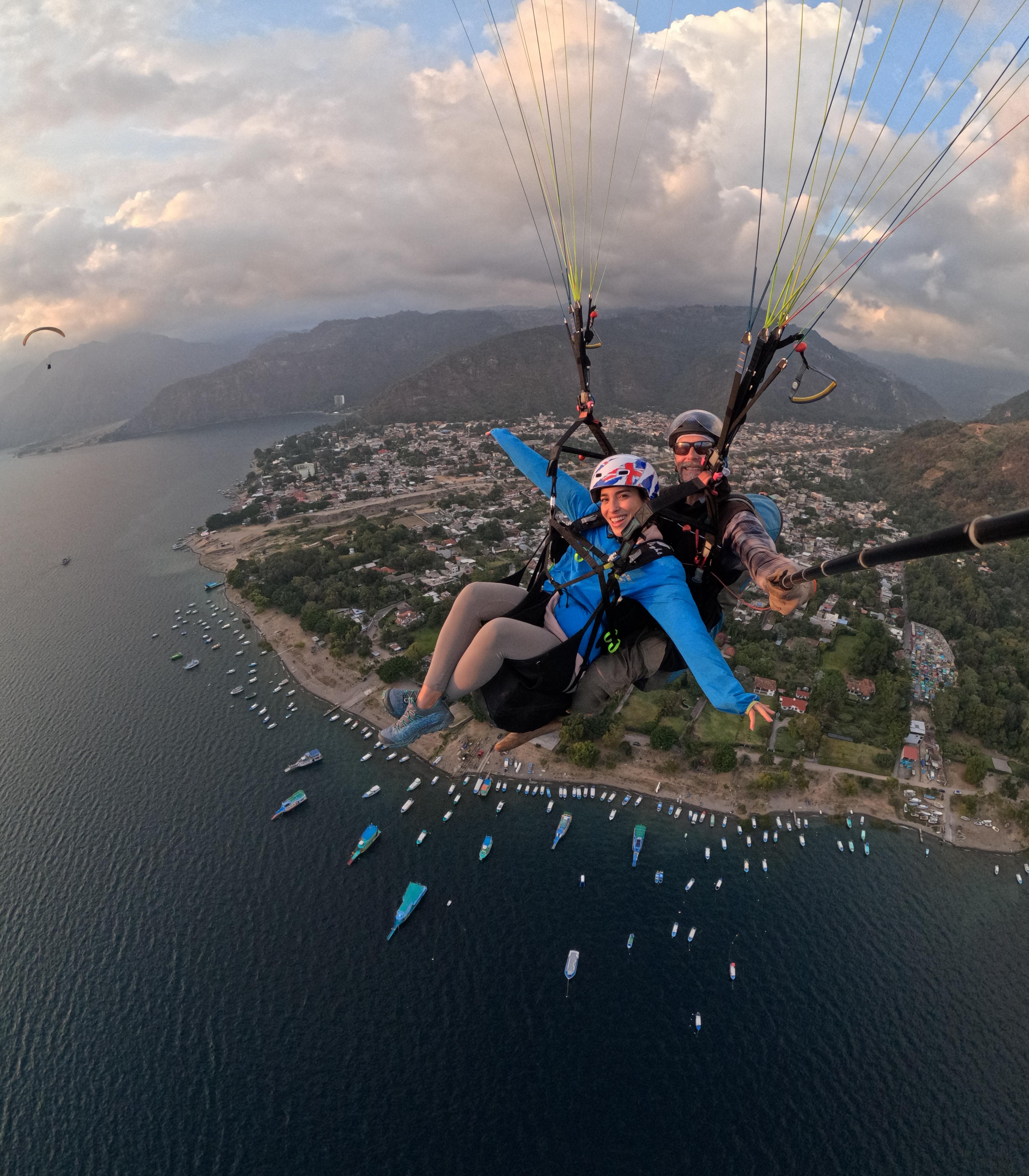 A beautiful young woman smiling at the camera on a mountain field