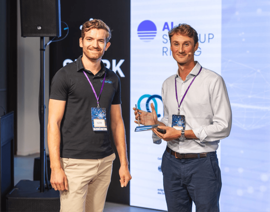 two men are standing on stage holding an award