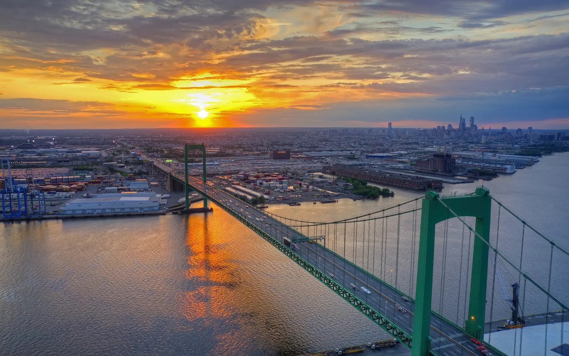 Aerial view of the Walt Whitman Bridge at sunset with the Philadelphia skyline in the distance