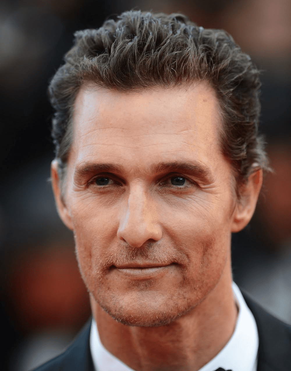 Woman in pink leather jacket crouching outdoors at night