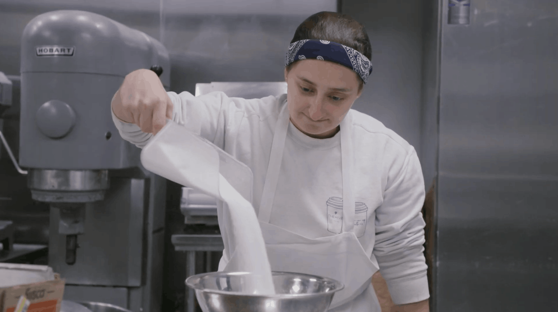 chef pours sugar into a bowl while cooking in her cloudkitchen