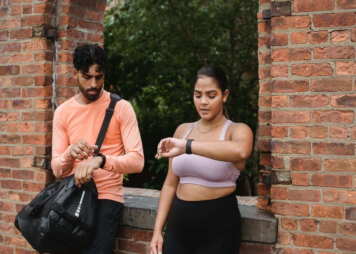 Man and woman looking at their fitness werables