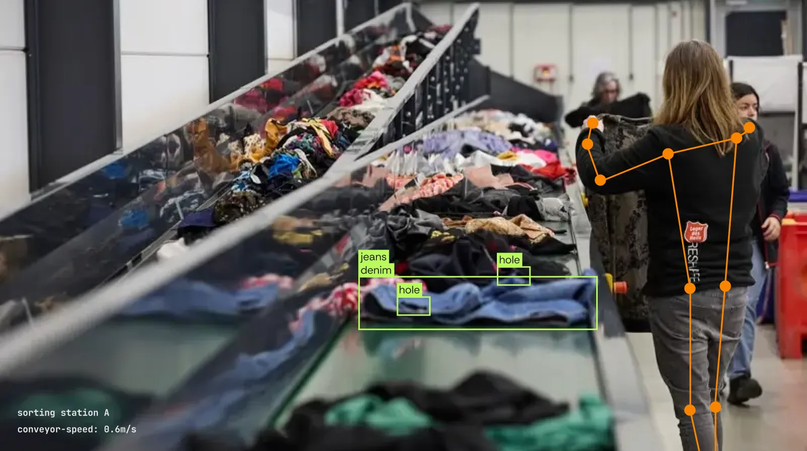 An employee of the Salvation Army ReShare inspects clothing on a conveyor belt full of colourful textiles in the Sympany sorting hall.
