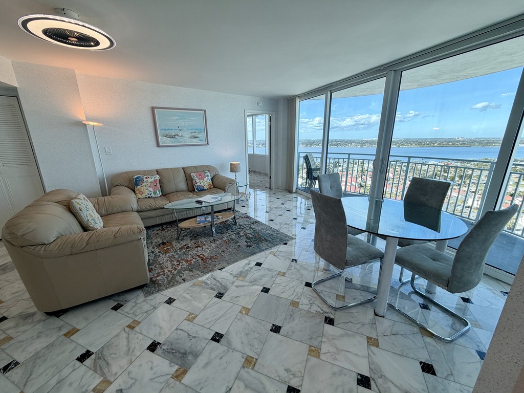 Living room and glass dining table by the windows, Unit 24NW at Peck Plaza, a vacation rental in Daytona Beach Shores