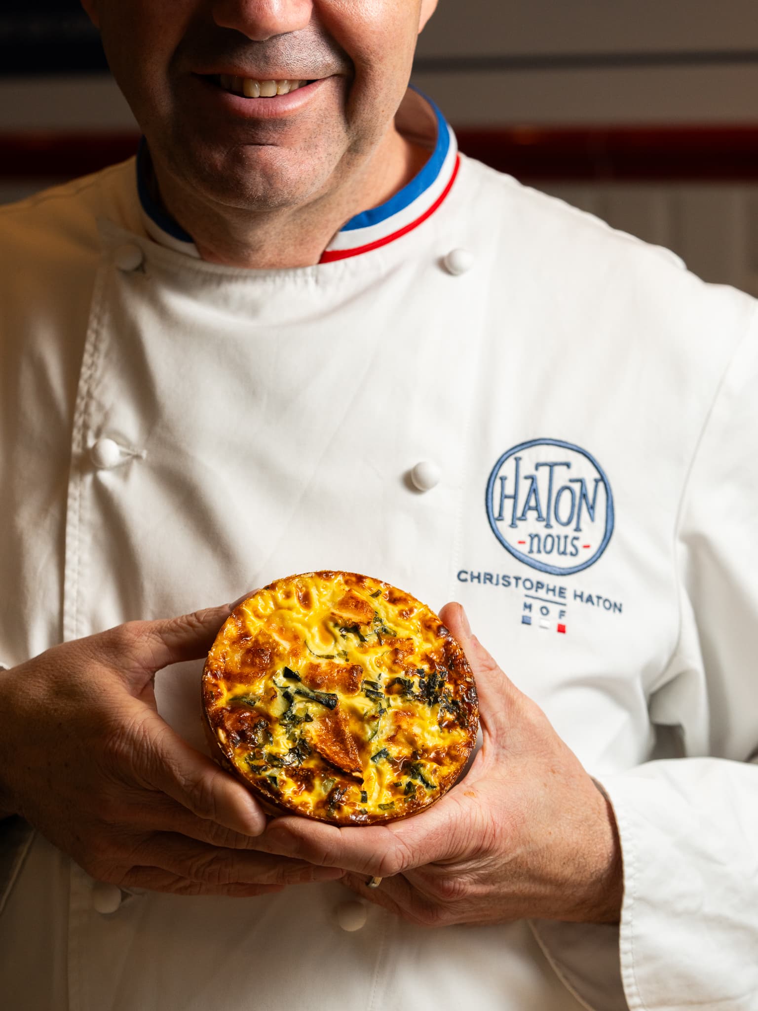 Christophe Haton, Meilleur Ouvrier de France, présentant une quiche HATON-nous, produit signature de son comptoir parisien.