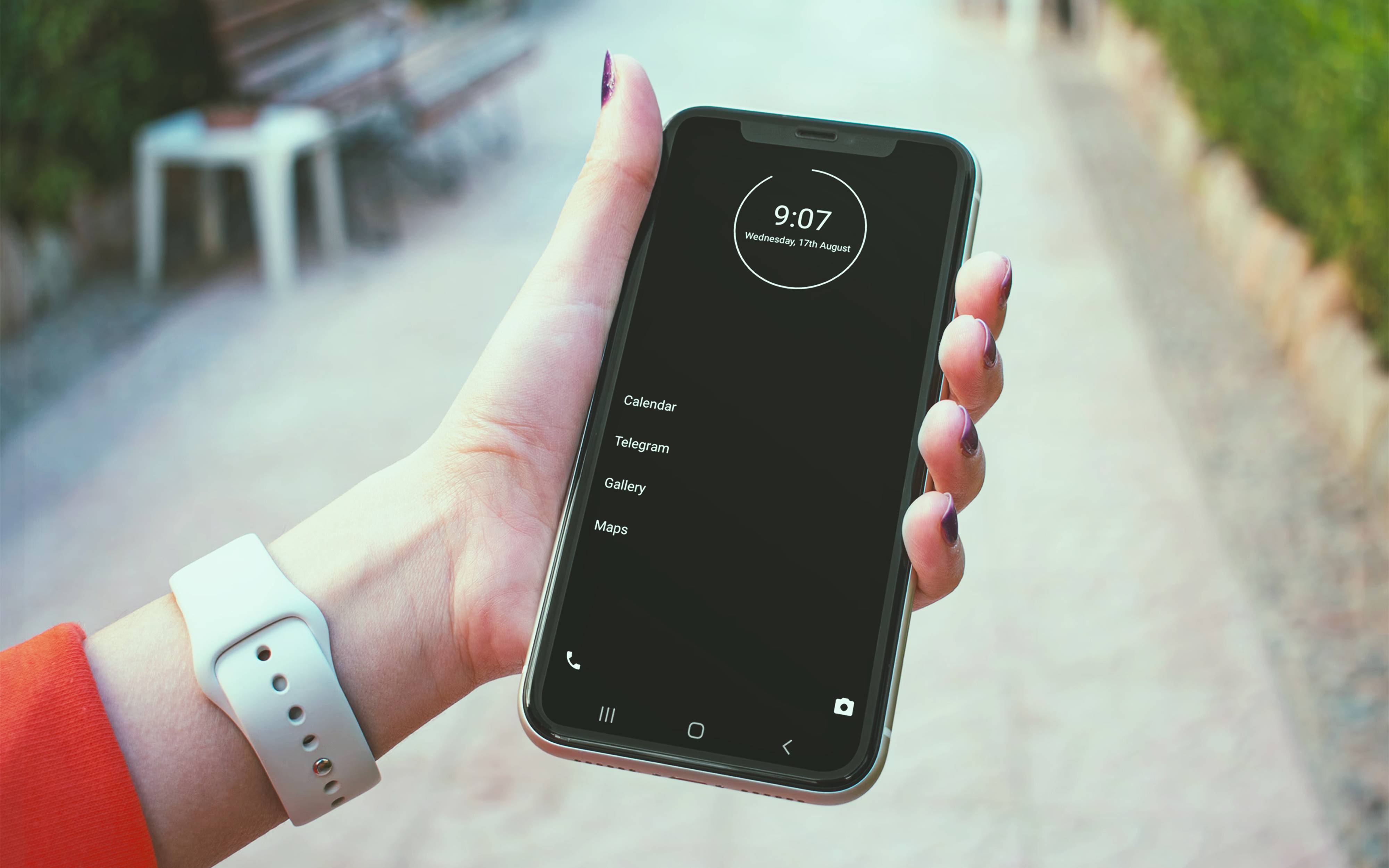 Hand holding a smartphone with minimalist phone app interface outdoors