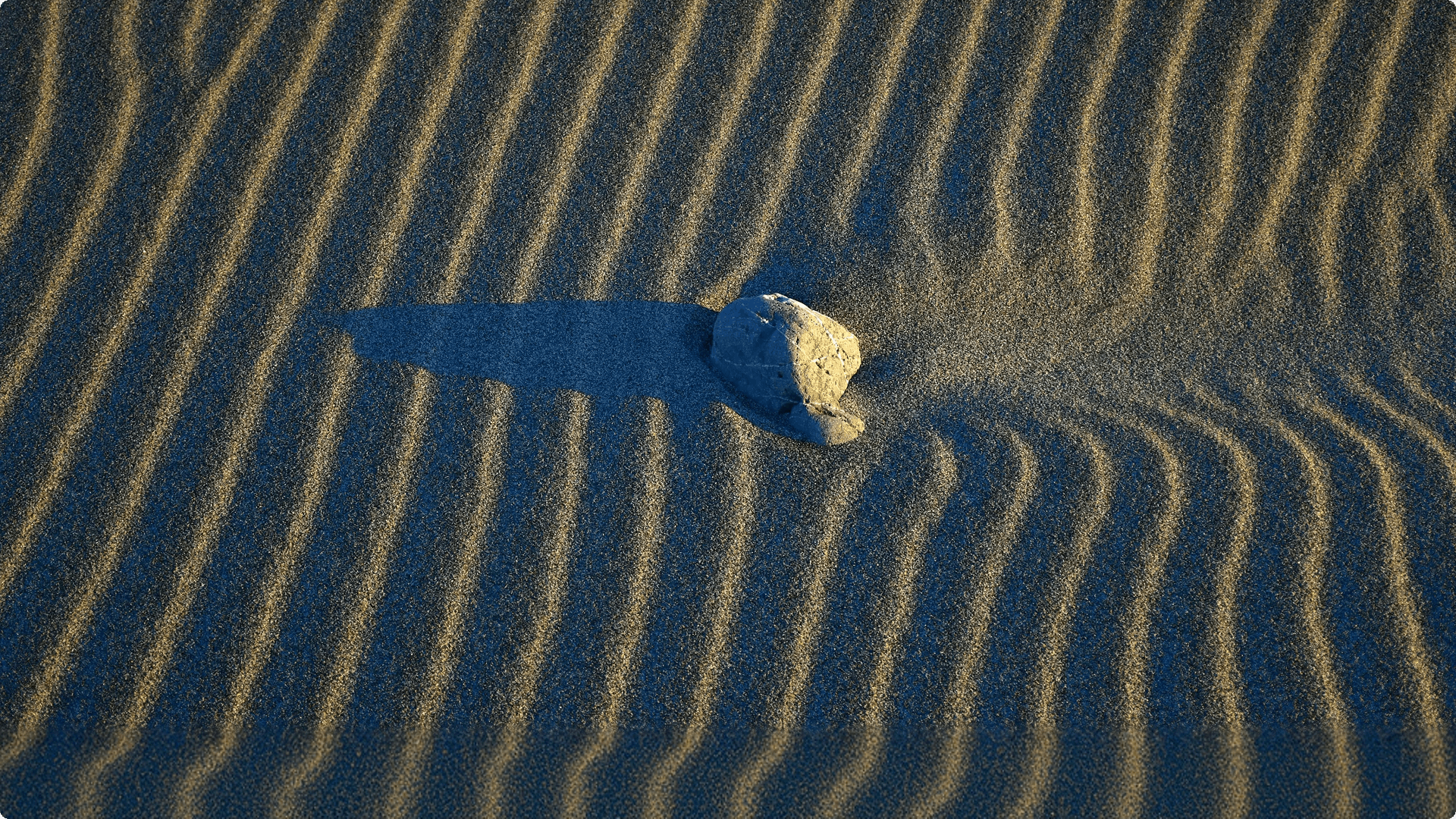 Abstract motion-blurred light patterns in warm gold and green tones against a dark background.