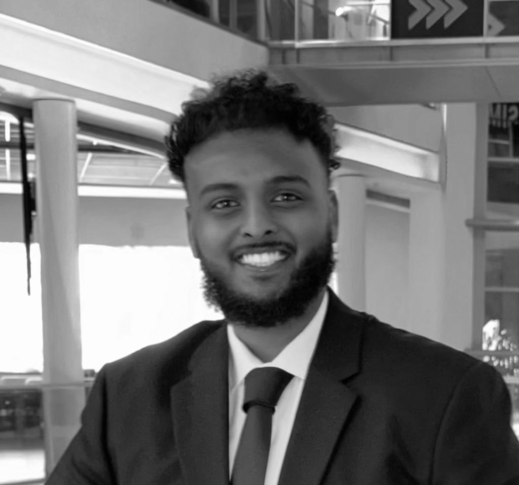 Portrait of a laughing person with curly hair wearing a white shirt