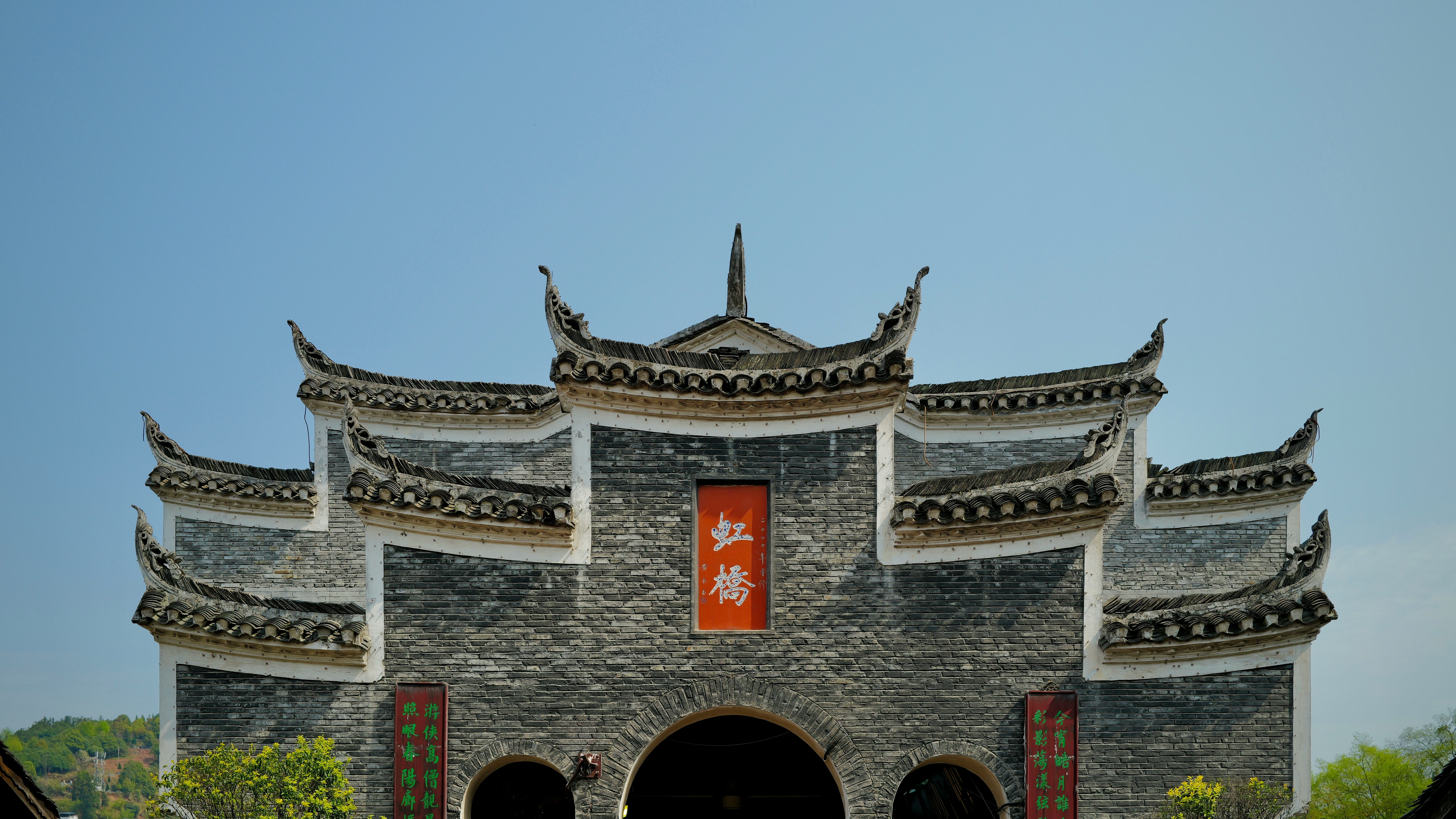 An ornate chinese archway stands against a clear sky.