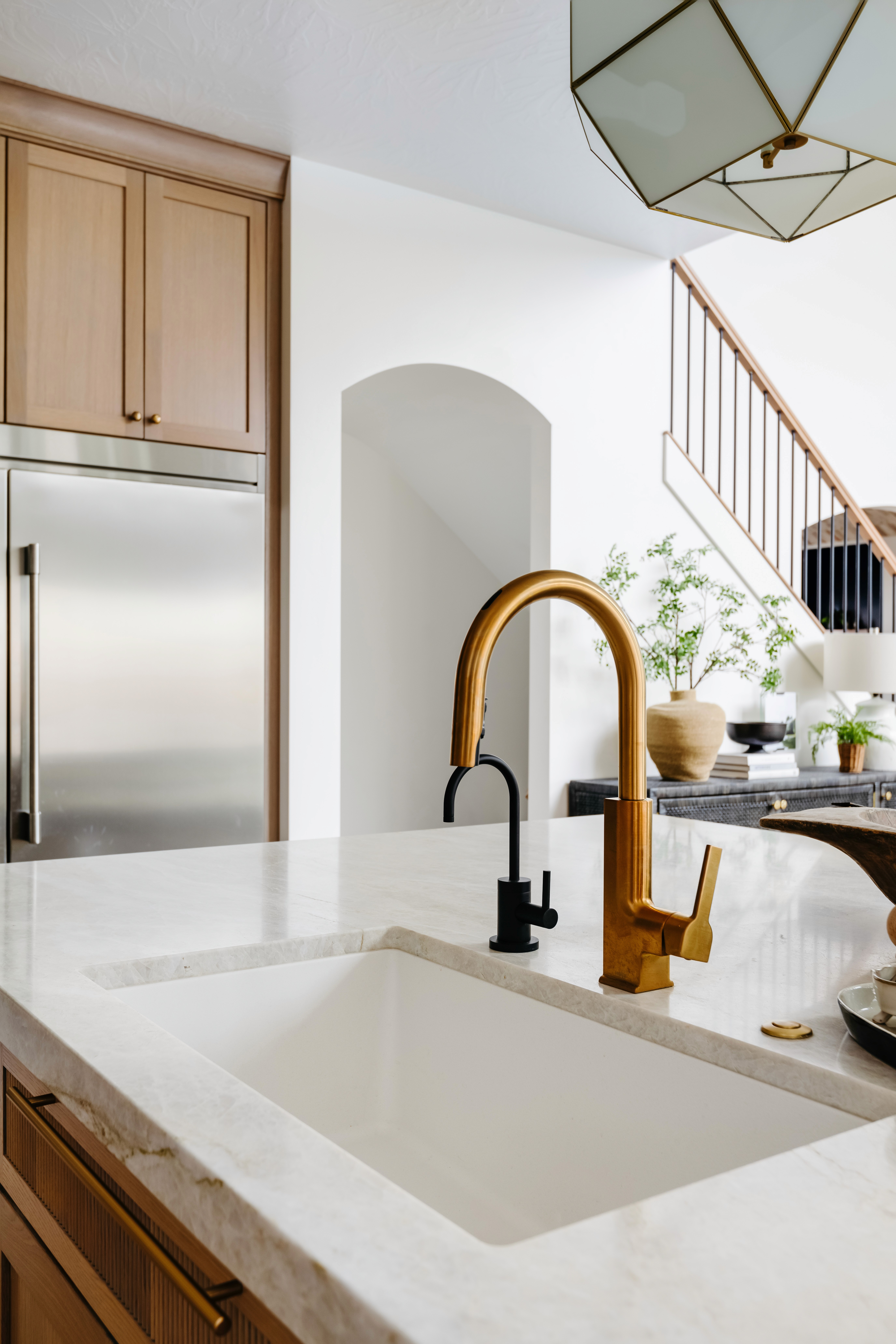 Kitchen in a Hurricane, Utah custom home with a brushed gold kitchen faucet and a matte black RO faucet.