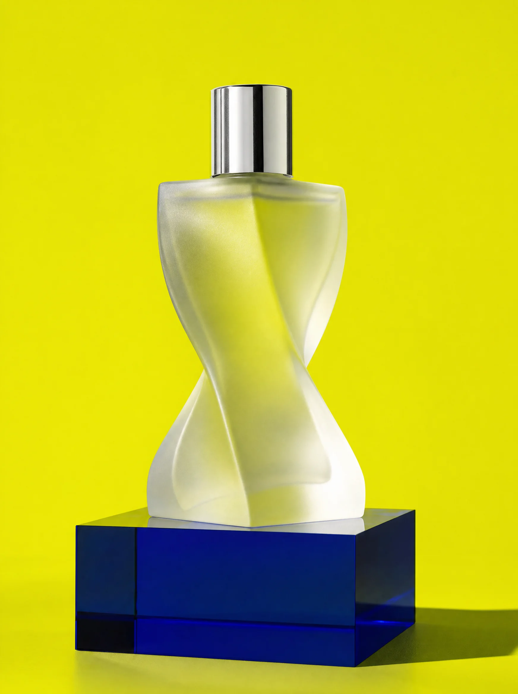 Twisted glass perfume bottle on a cobalt block against yellow, Verre No. 4