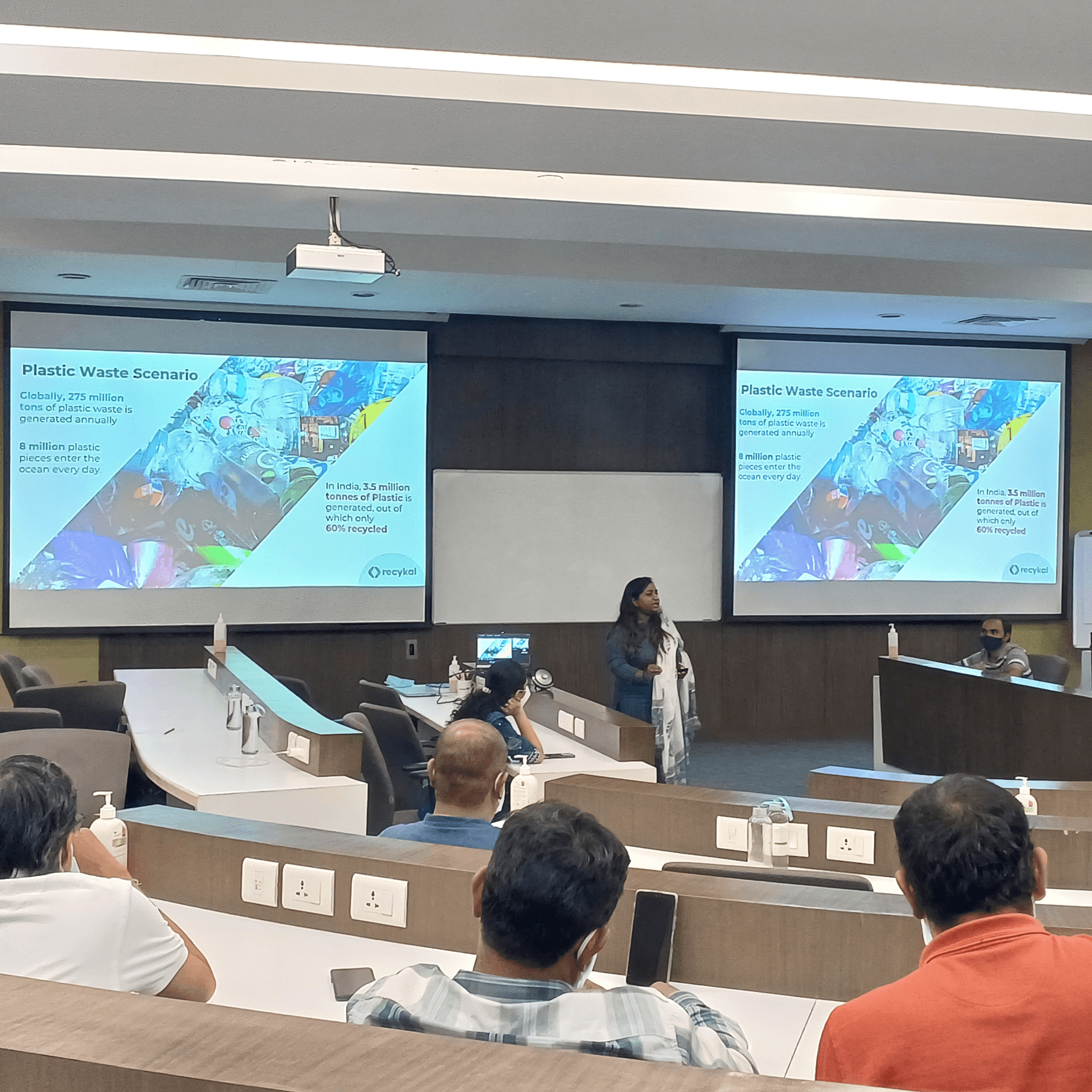 Woman in red outfit poses by a red telephone booth.