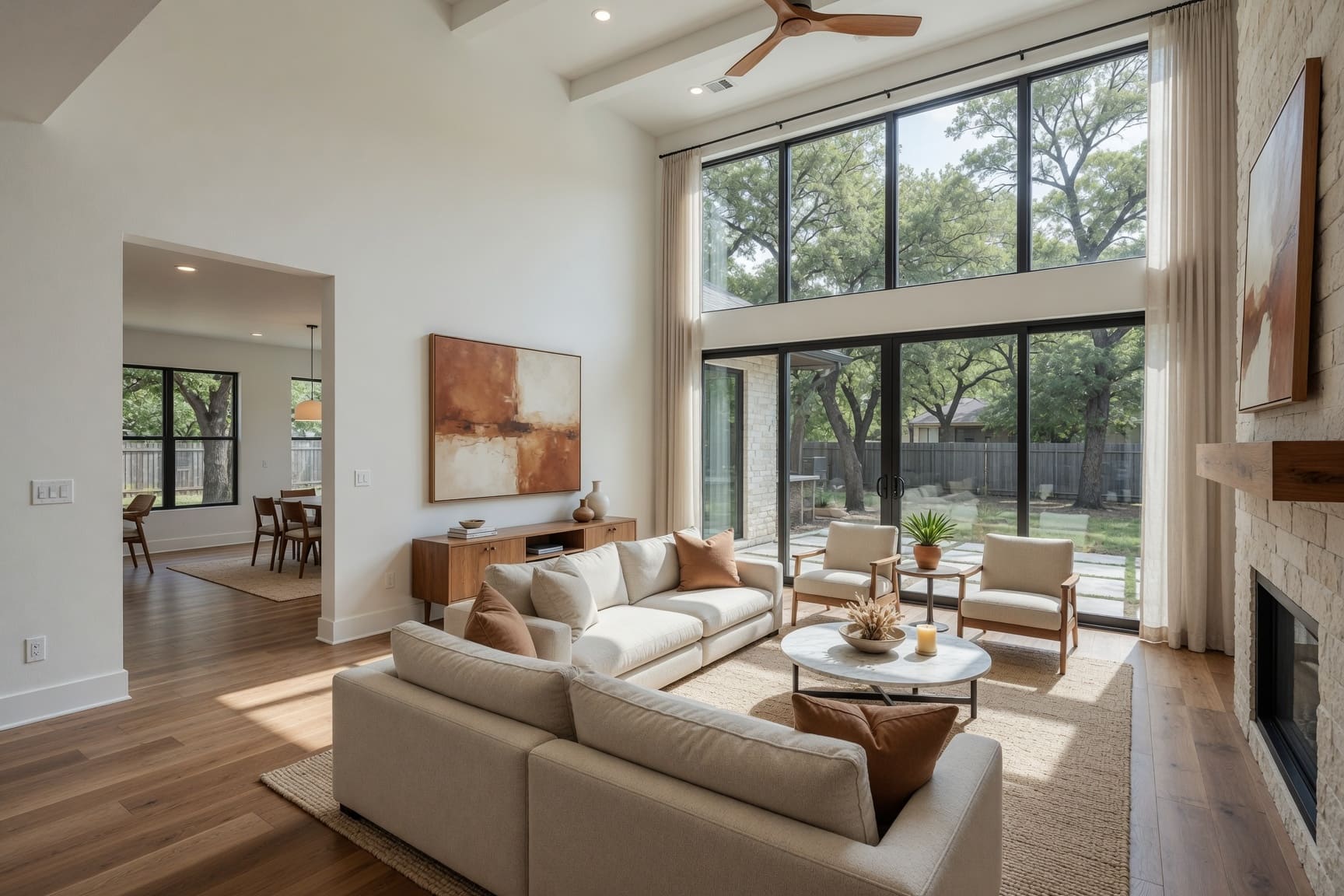 Open plan living room with floor-to-ceiling windows and tree views