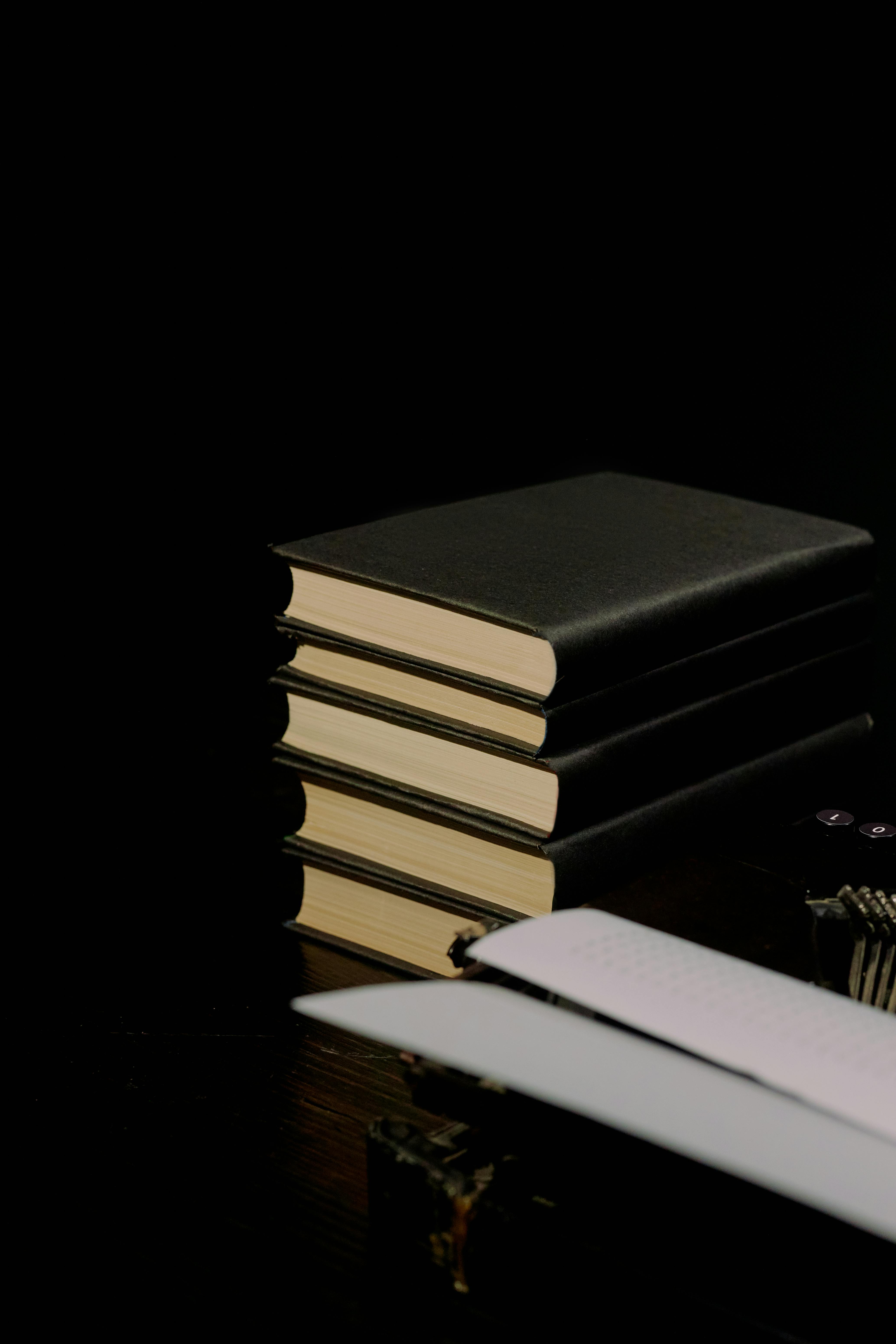 Black books in hard cover on black table