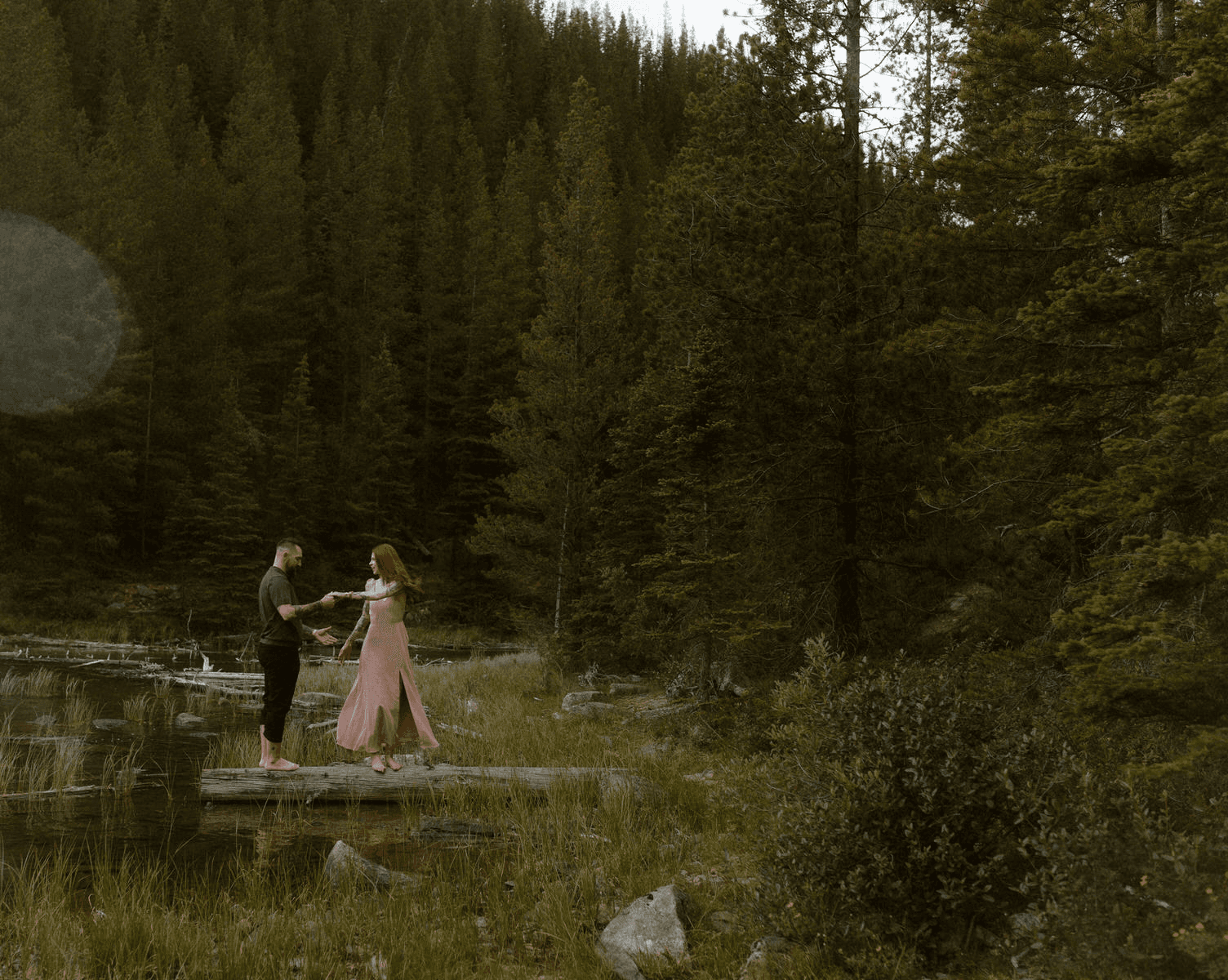 Wedding couple under veil with sunlight illuminating brides ice blue eyes
