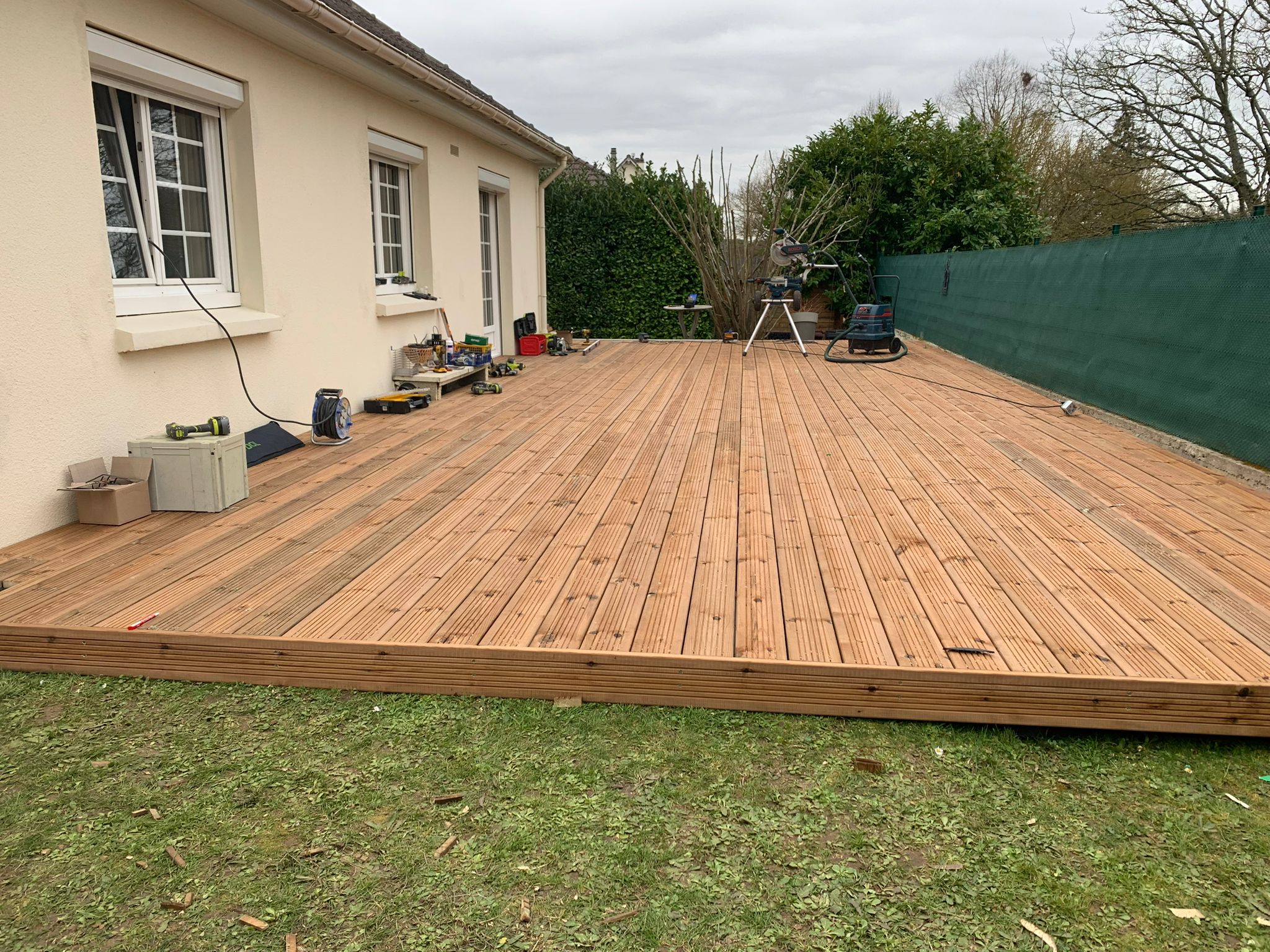 Stacked square glass jars filled with golden serum and bubbles, silver lids—luxury skincare packaging on a light background.
