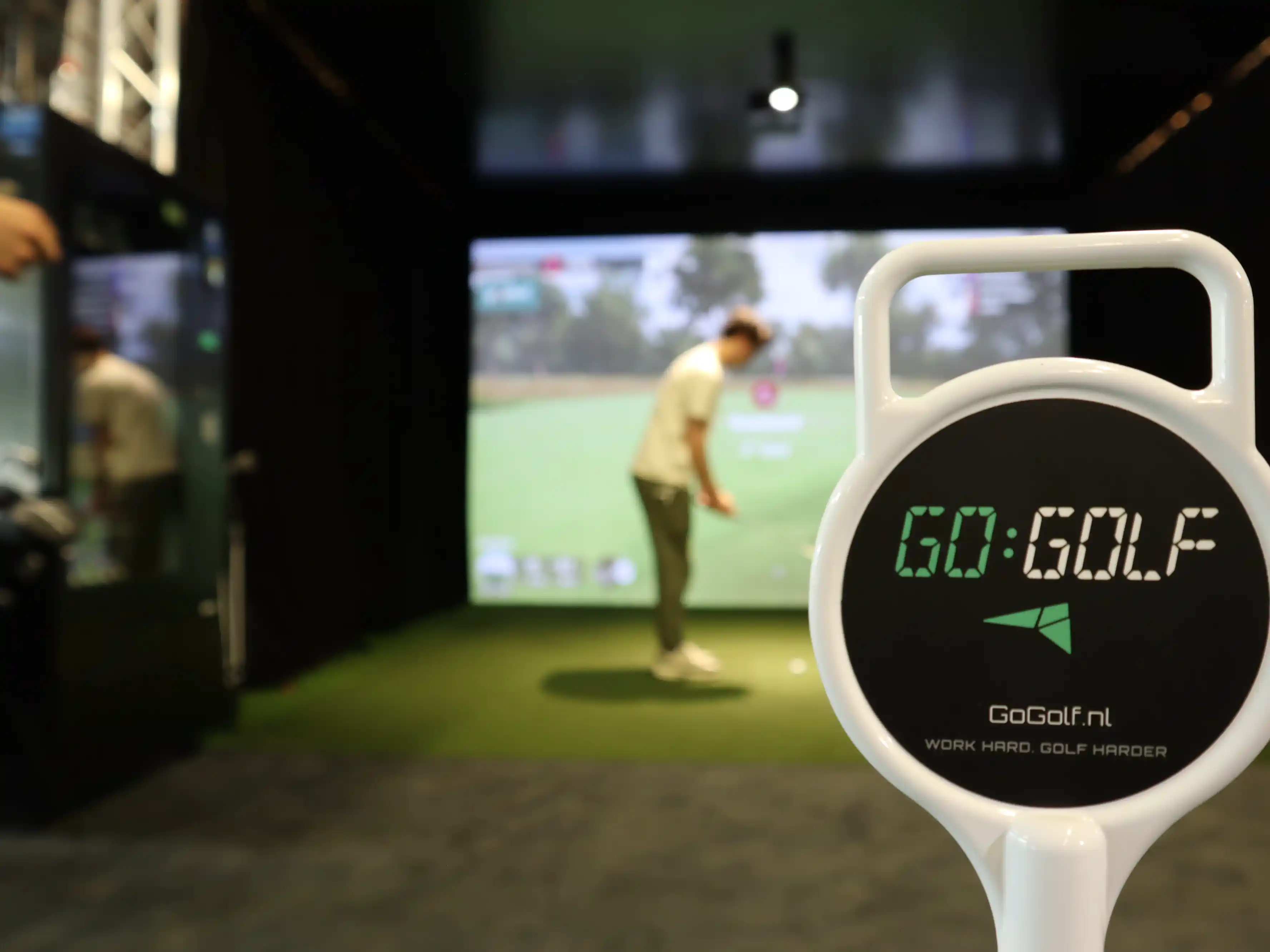 gogolf-amsterdam-trackman-indoor-golf-bay-met-golfer-in-actie-en-logo
