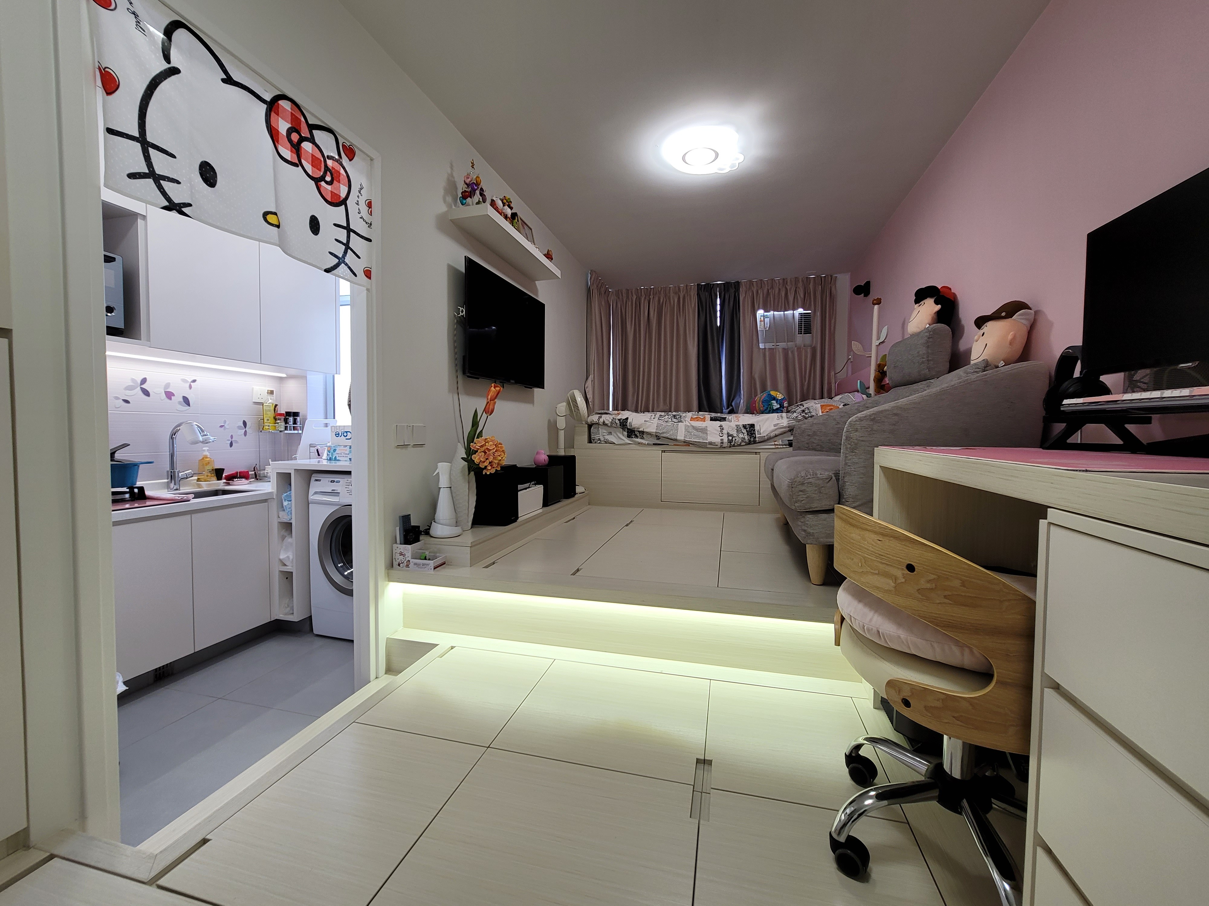 Functional storage and a built-in washing machine define this compact laundry corner in a Hoi Tat Estate apartment with sleek stainless finishes.