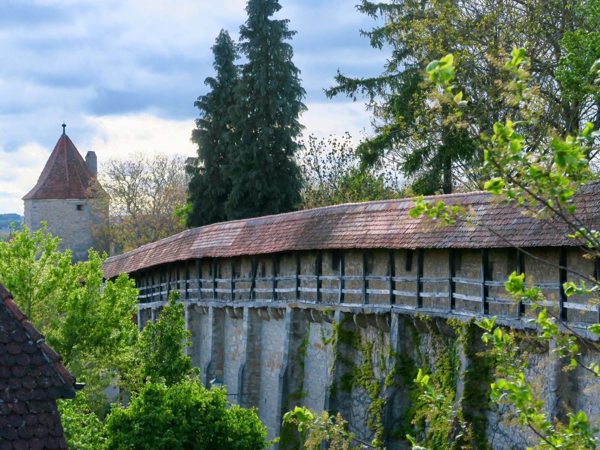 Panoramablick auf die gut erhaltene Stadtmauer von Rothenburg ob der Tauber mit historischen Türmen.