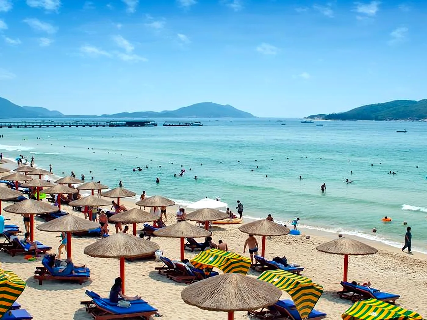 Sanya white sandy beach with umbrellas and people