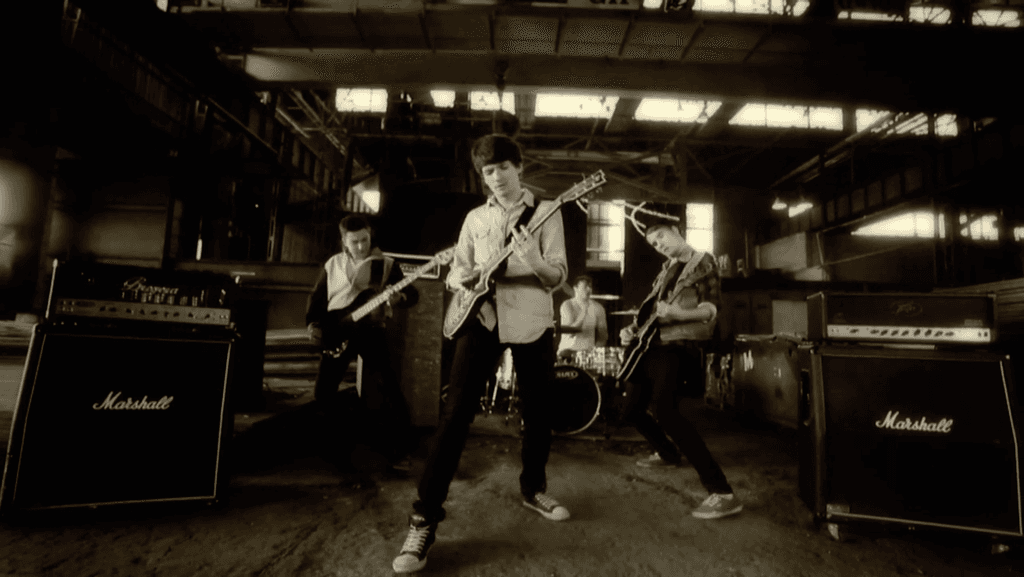 plakat 20 inicjatywy zdjęcia grupowego, napis namalowany pędzlem, informacje na karteczce memo oraz poprzednie zdjęcia przedstawione w formie wieży