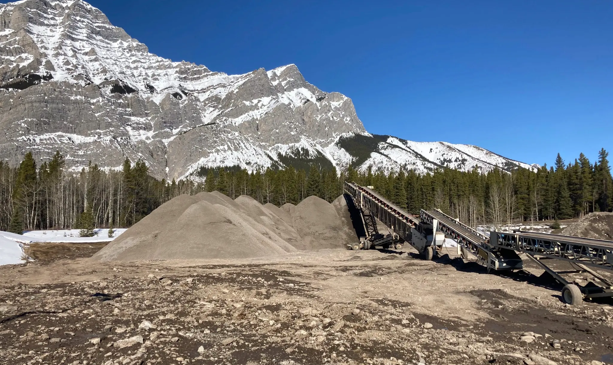 Crushed granular stockpiles and telescoping stacker conveyors at a Storage Yard in Kananaskis, Alberta