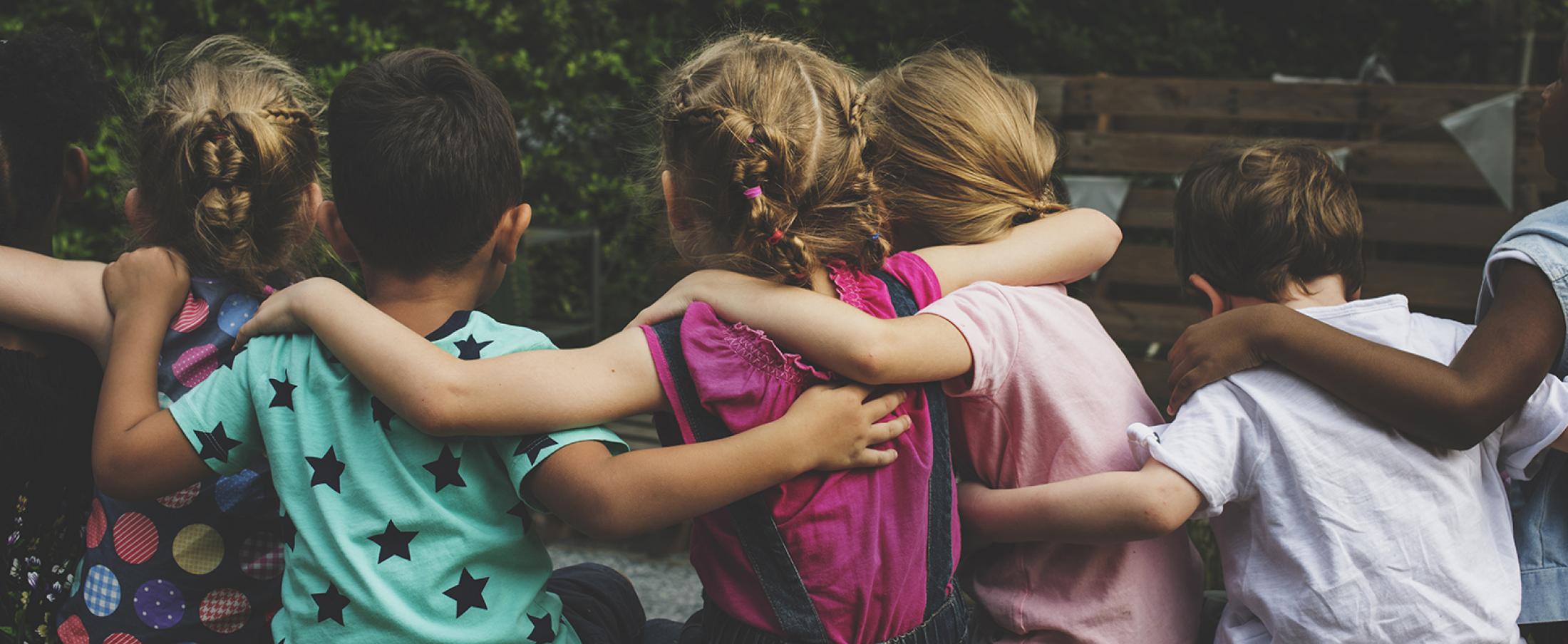 Niños abrazándose en un entorno escolar – categoría Educación