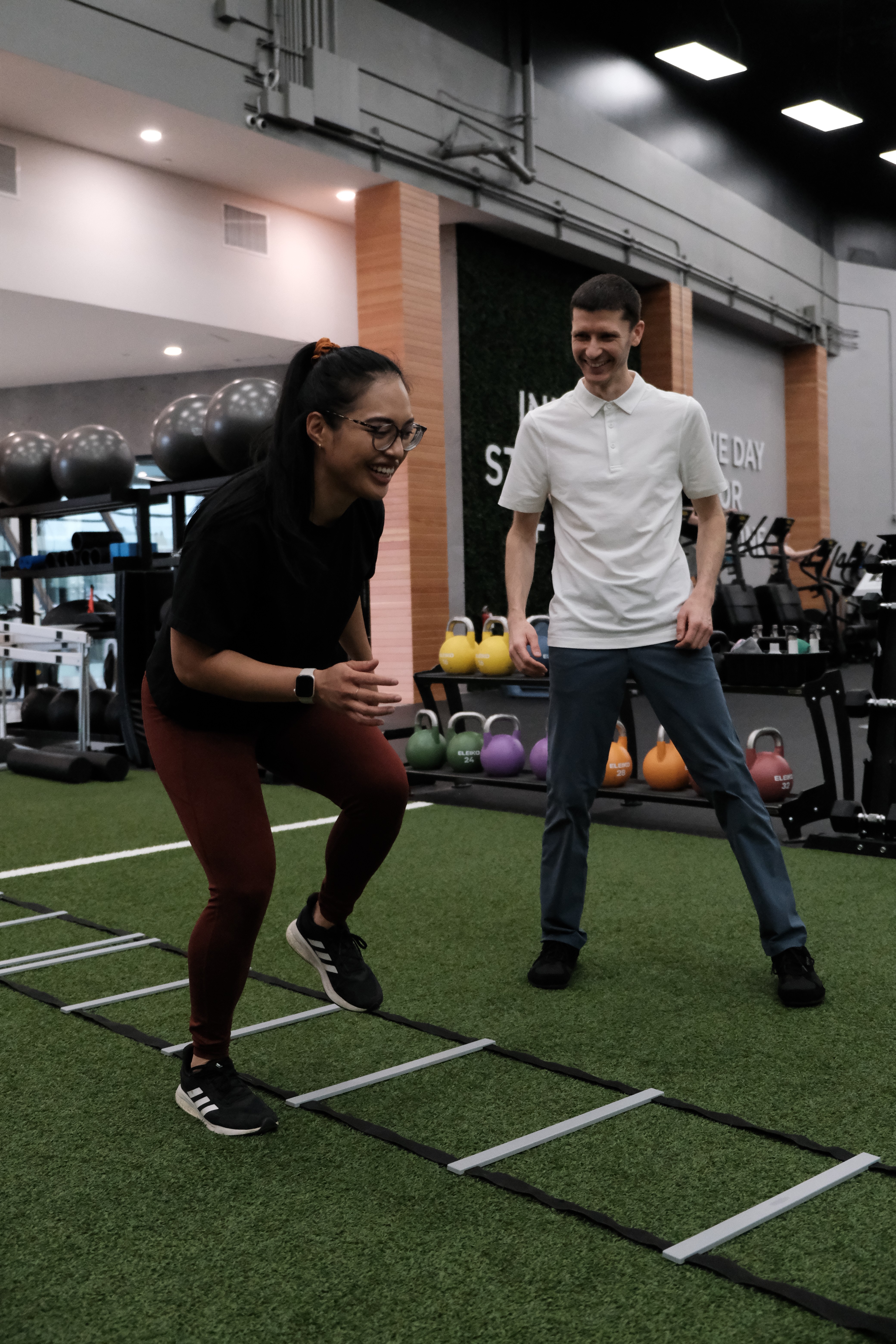 physiotherapist inspecting a patient's technique while exercising 