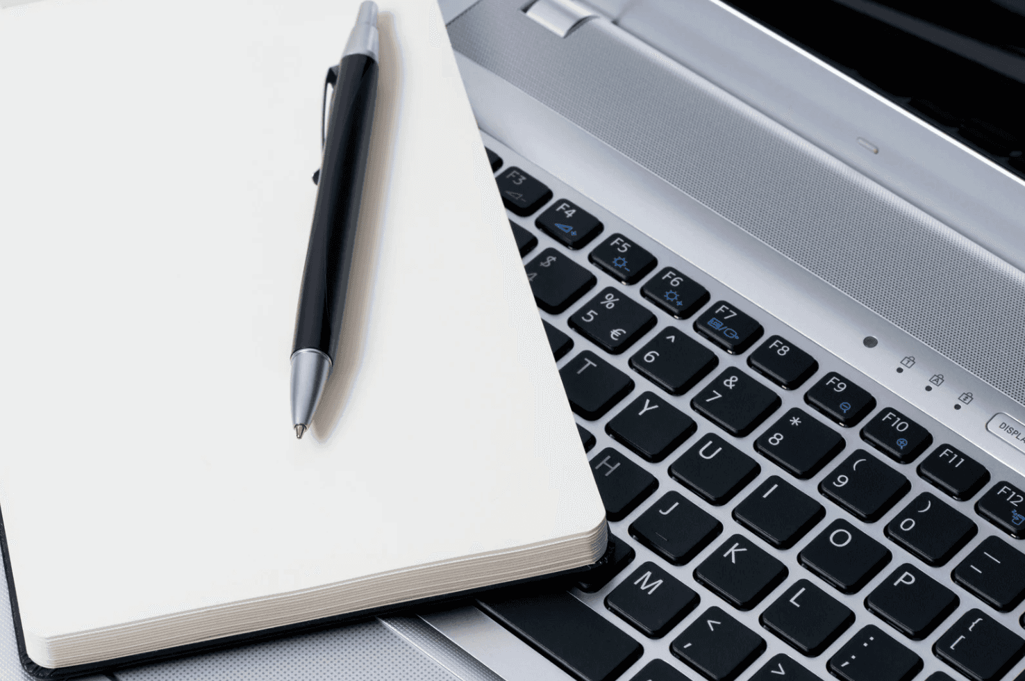 Amazon seller planning post-holiday ad strategy adjustments with laptop and notebook for Q1 campaign optimization