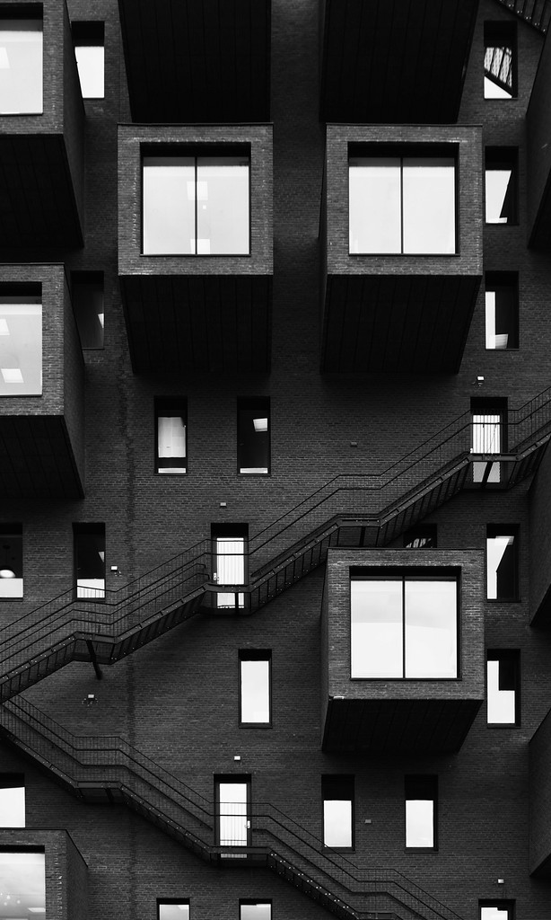 blak white image showing a lot of cubical windows on a mordern squared building.