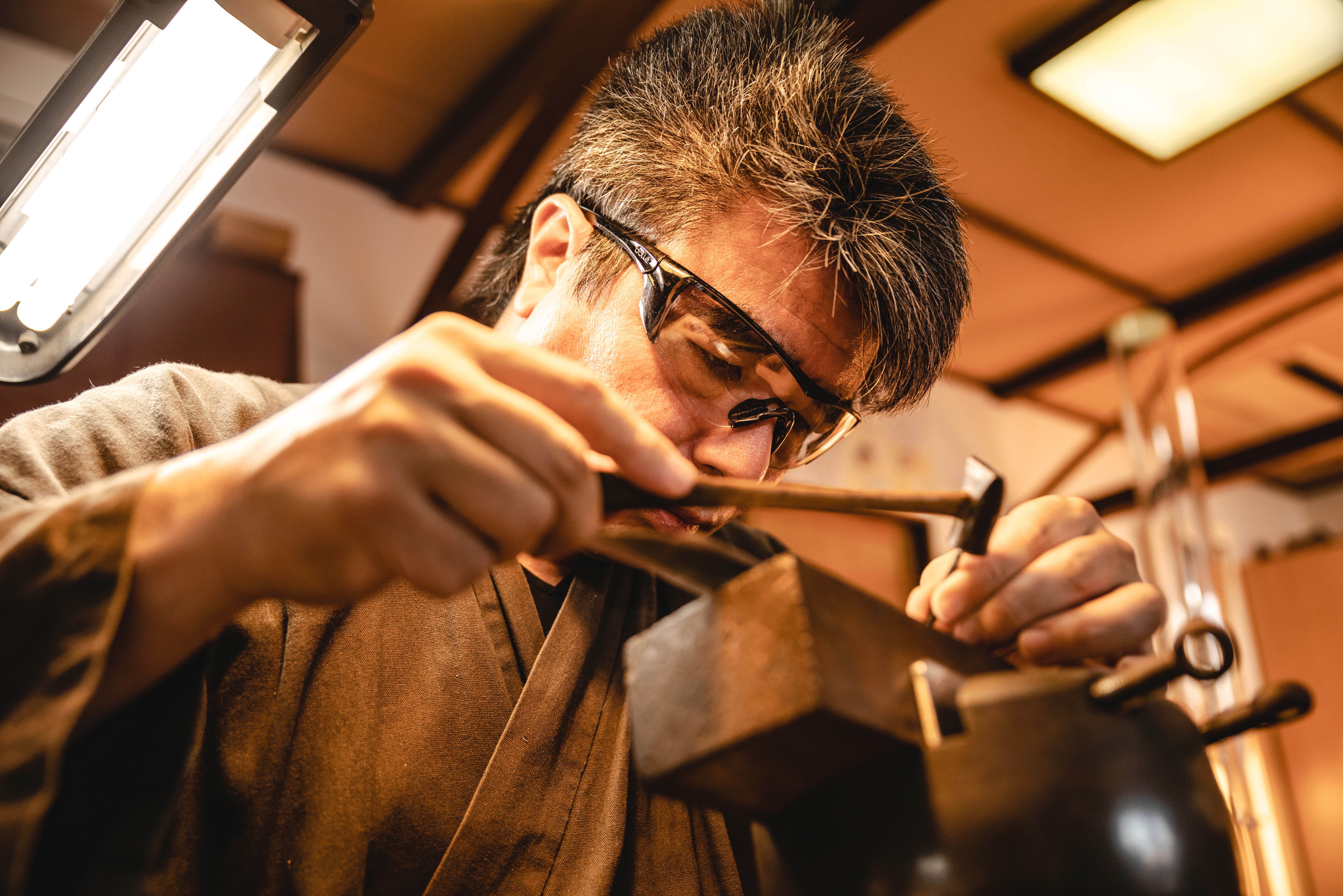 Swordsmiths hammering iron in a team