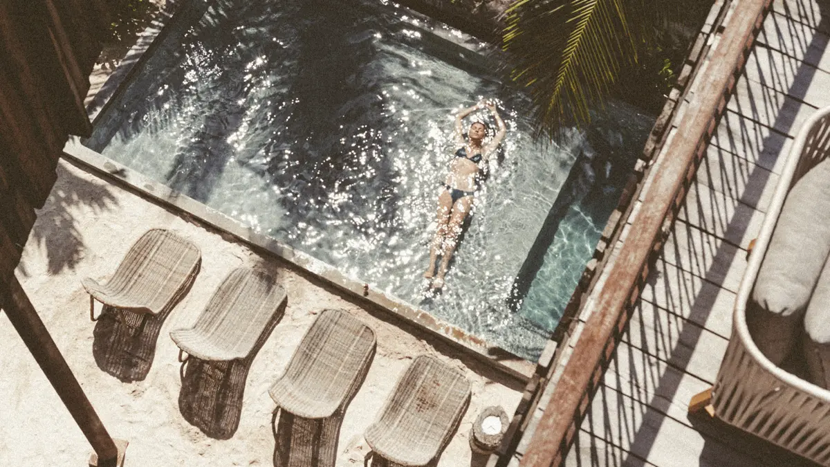 Two-story suite with terrace swing, sofas, table, and private pool. Surrounded by lush palm jungle at Be Tulum.