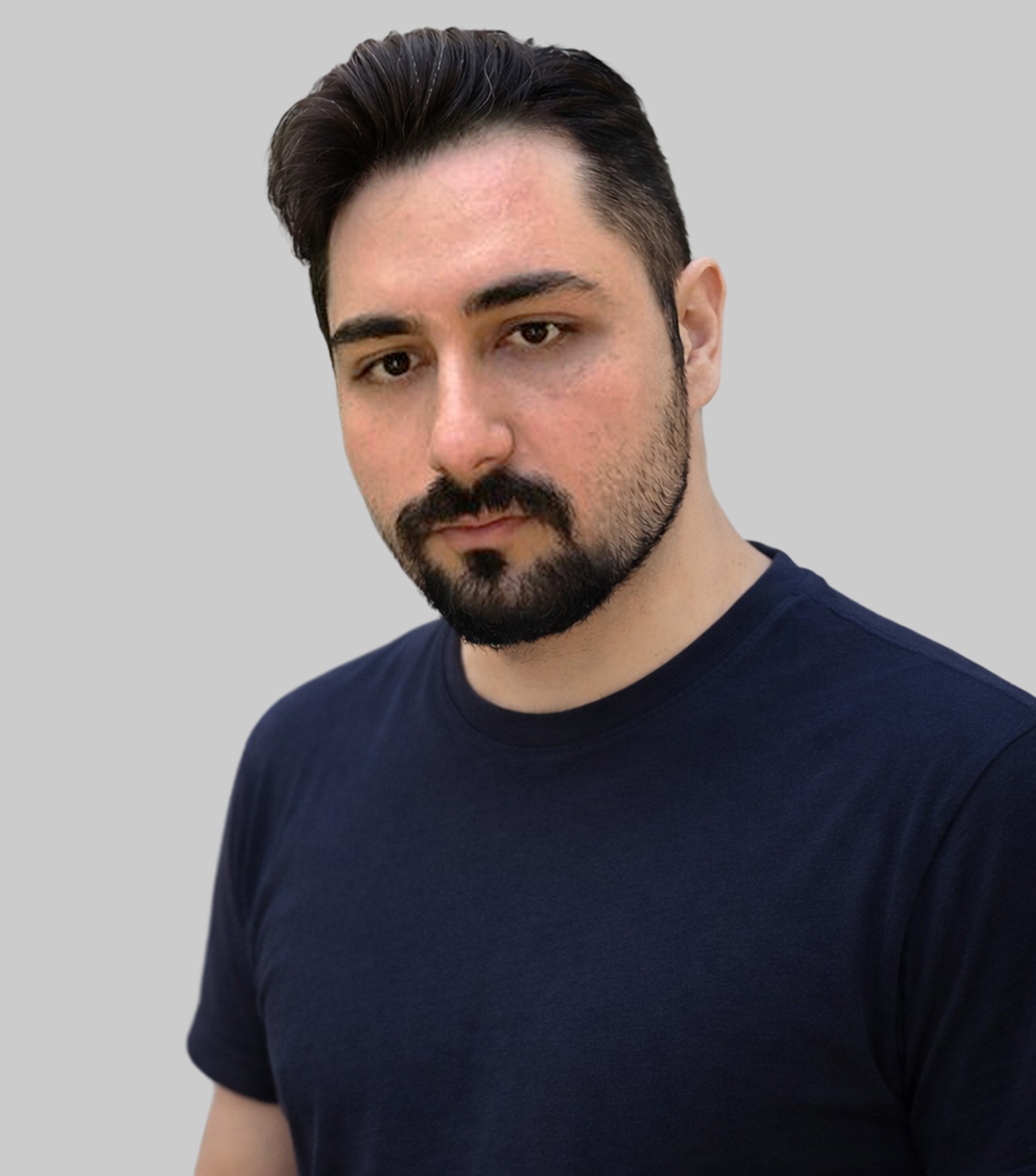 A young man in a white t-shirt stands against a light-colored background.