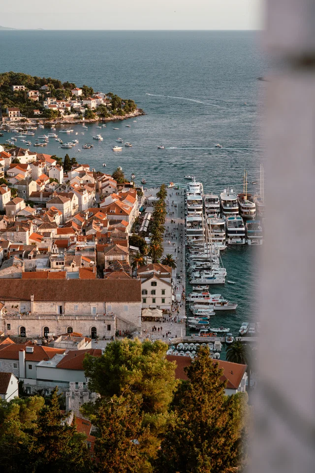 Hvar Town harbour at golden hour, boats moored along the waterfront