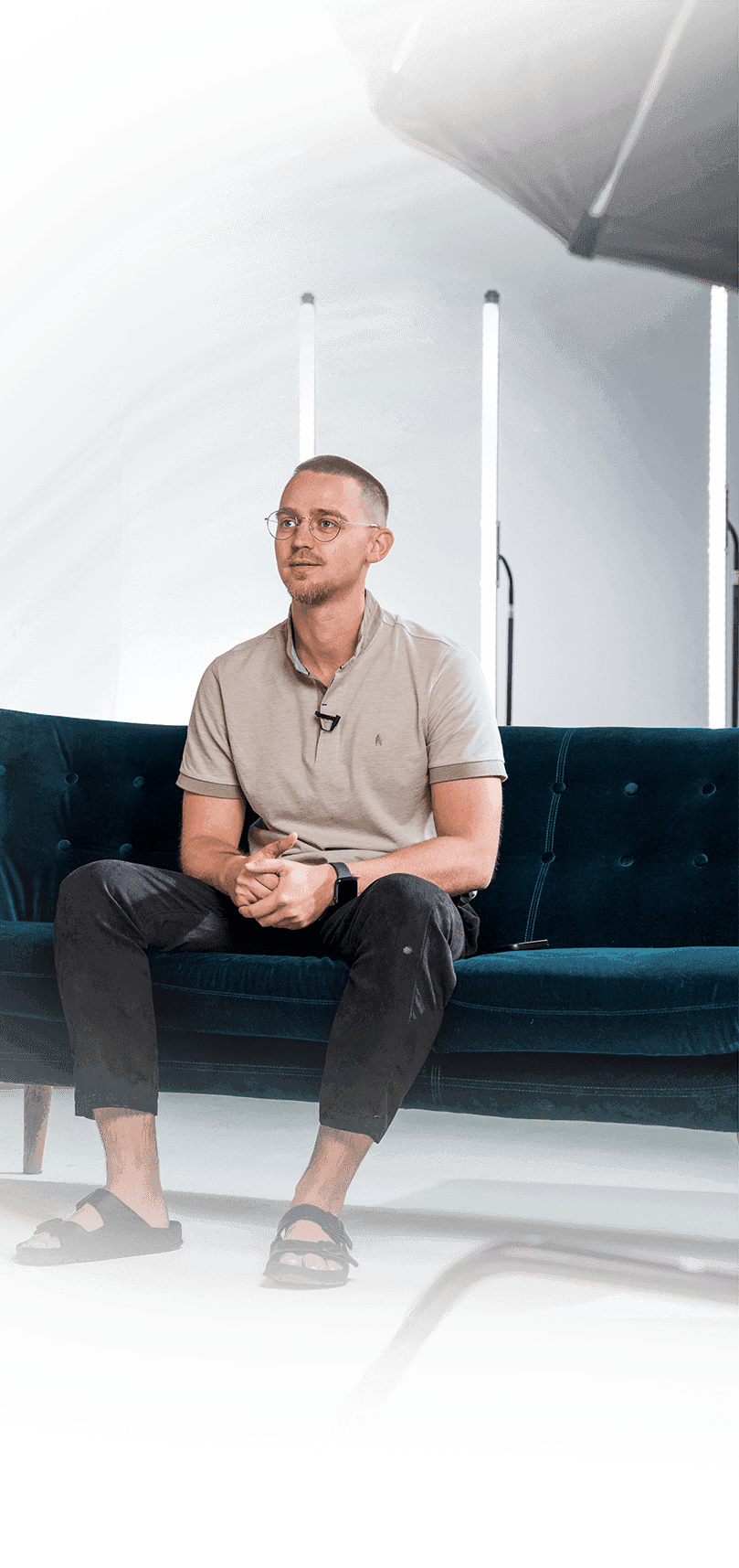 Portrait von Alexander Friesen, Videoproduzent und Gründer von AF-Films, sitzend auf einem blauen Sofa im Studio während eines Videodrehs.
