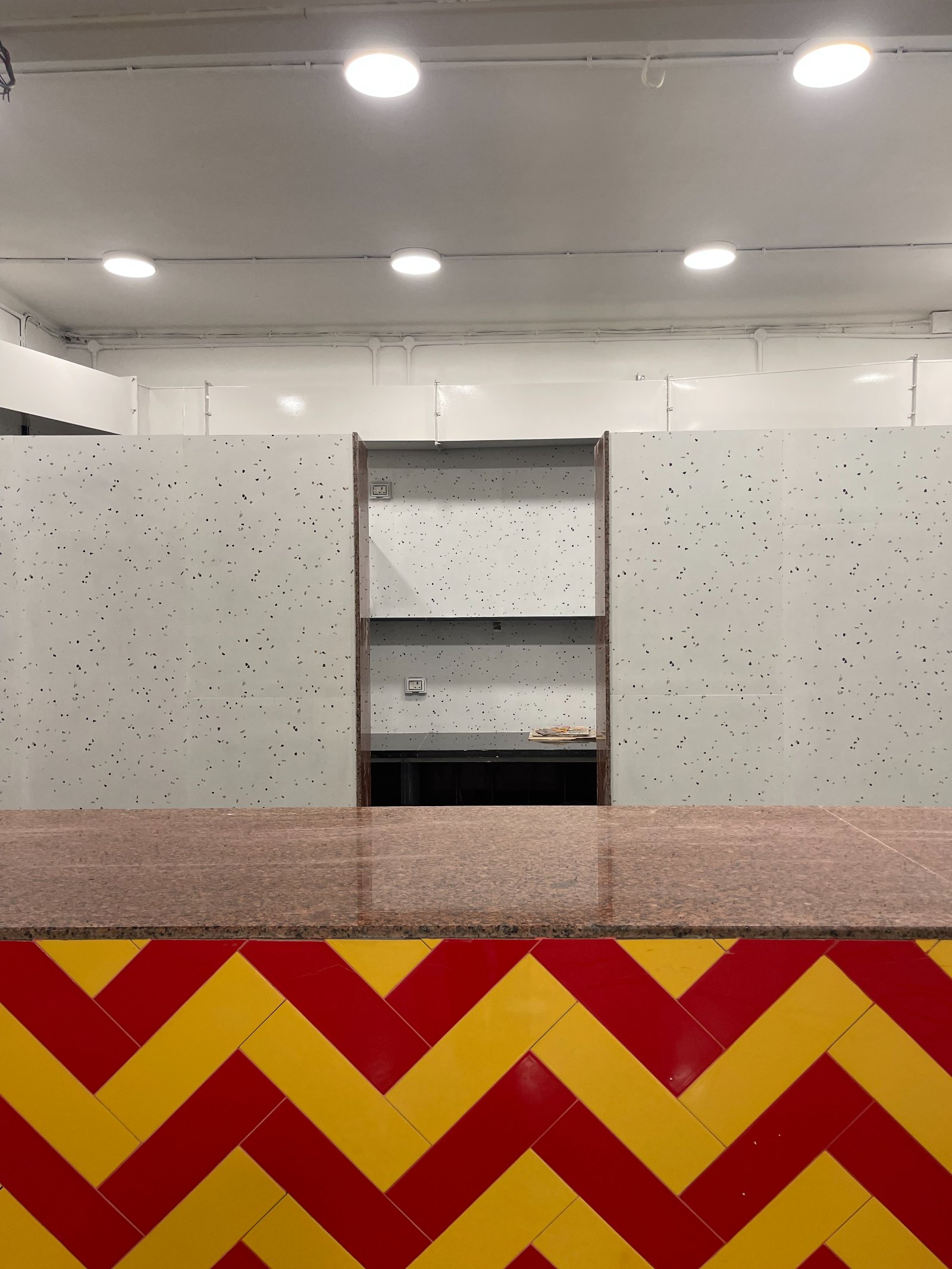 Nature-inspired preschool entrance with sculptural tree partitions and suspended green leaf ceiling panels.