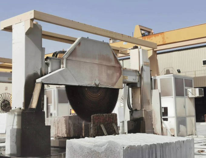 Gantry Cutting Machine installed in a busy stone-processing facility, demonstrating its capability to perform large-scale cuts on various stone types with consistent precision.