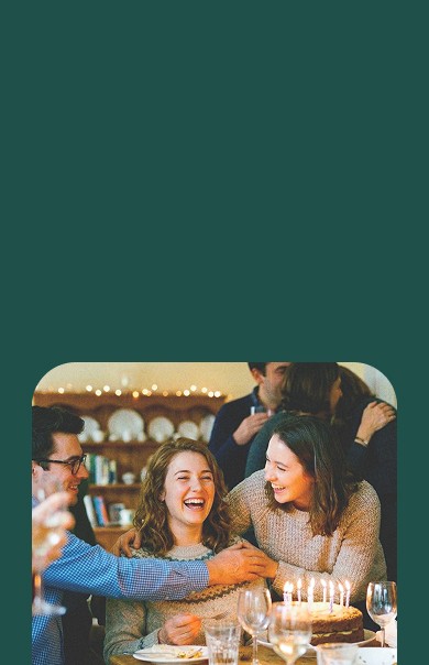 four boys laughing and sitting on grass during daytime