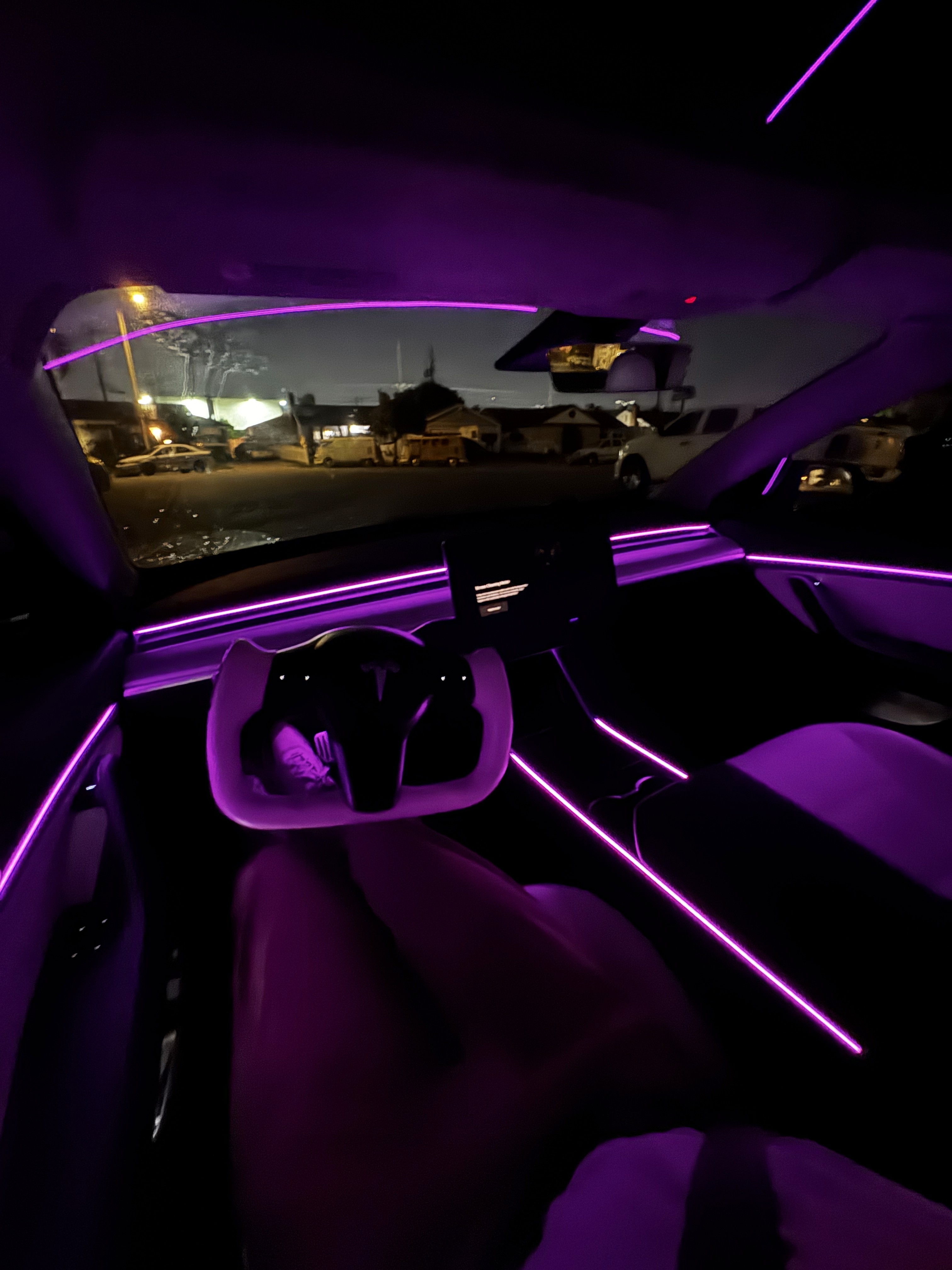 Wide cabin shot of Tesla Model 3 with ambient lighting glowing